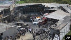 Petugas polisi dan regu penyelamat memeriksa lokasi ledakan di sebuah pabrik petasan di Tangerang, di pinggiran Jakarta, Indonesia, Kamis, 26 Oktober 2017.