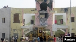Soldiers and people gather at the scene following an attack by a suicide bomber who drove a car laden with explosives into a compound run by local militias in the southern port city of Aden, Yemen, August 29, 2016. 