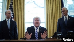 FILE - President Trump reacts to the AHCA health care bill being pulled by Congressional Republicans before a vote as he appears with Secretary of Health and Human Services Tom Price (L) and Vice President Mike Pence (R) in the Oval Office of the White House in Washington, March 24, 2017. 