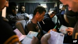 FILE - Israeli border police checks the ID's and work permits of Palestinian workers as they head back home to the West bank at the exit of the coastal city of Ashkelon, Israel, Nov. 11, 2014.