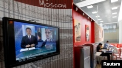 A television screen shows former U.S. spy agency contractor Edward Snowden during a news bulletin at a cafe at the Moscow's Sheremetyevo airport, Russia, June 26, 2013.
