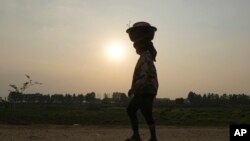 ស្ត្រី​ម្នាក់ទូល​កន្ត្រកក្បែរ​បឹង​ត្រពាំងមួយ ក្នុង​រដូវប្រាំង​ខាង​ក្រៅ​រាជធានី​ភ្នំពេញ​ នៅ​ថ្ងៃ​សុក្រ ទី២២ ខែ​មីនា ឆ្នាំ​២០២៤។