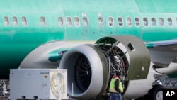 Seorang pekerja melintas mesin sebuah Boeing 737 MAX 8 yang tengah diproduksi untuk maskapai American Airlines di fasilitas perakitan milik Boeing Co. di Renton, Washington, 13 Maret 2019 (foto: AP Photo/Ted S. Warren)