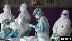 រូបឯកសារ៖ ក្រុមគ្រូពេទ្យ​ត្រៀម​ប្រមូល​សំណាក​​ពី​ប្រជាជន ក្នុង​អំឡុងពេលនៃ​ការ​ធ្វើ​តេស្ត​រក​ជំងឺ​កូវីដ១៩​ពី​ពលករ​ចំណាកស្រុក ក្នុង​ខេត្ត Samut Sakhon ប្រទេស​ថៃ​ ថ្ងៃទី២៧ ខែមករា ឆ្នាំ២០២១។ 