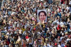 FILE - People participate in a rally in Yangon, in support of Myanmar's State Counsellor Aung San Suu Kyi, as she prepares to defend Myanmar at the International Court of Justice at The Hague against accusations of genocide against Rohingya Muslims.