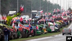 Sejumlah petani Polandia memblokade jalan utama di Lomianki, dekat Warsawa, sebagai bentuk protes untuk menuntut pengaturan impor pangan yang berasal dari Ukraina, pada 6 Maret 2024. (Foto: AP/Czarek Sokolowski)