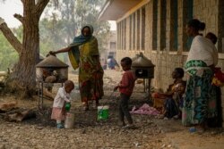 Families of refugees prepare injera, a traditional Ethiopian food, in the yard of one of many schools in Mekelle, Ethiopia, that are now camps for displaced families, June 3, 2021. (Yan Boechat/VOA)