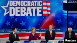 Para kandidat capres AS dari Partai Demokrat: Walikota South Bend Pete Buttigieg, mantan Wapres AS Joe Biden dan Senator Bernie Sanders mendengarkan Senator Elizabeth Warren saat debat di Tyler Perry Studios, Atlanta, Georgia, 20 November 2019. (Foto: dok).