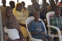 FILE - Woman and children detained by the Nigeria army who have no links to Boko Haram sit under a canopy before their release at the Giwa military barracks in Maiduguri, Nigeria, Feb. 12, 2016.