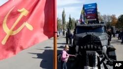 На архівному фото: Дівчинка оглядає вантажівку російського мотоклубу "Нічні вовки" під час параду в окупованому місті Луганськ, Україна, 14 вересня 2014 р. AP Photo/Darko Vojinovic
