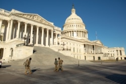 National Guard troops cross the grounds of the U.S. Capitol building on Capitol Hill in Washington, Jan. 10, 2021.