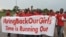 FILE - People shout slogans and hold a banner during a demonstration in Abuja, Nigeria.