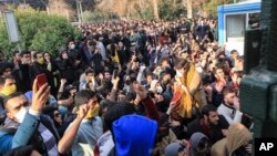 FILE - University students attend a protest inside Tehran University while anti-riot Iranian police prevent them from joining other protesters, in Tehran, Iran.