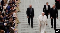 Pope Francis walks in the Paul VI Hall at the end of his weekly general audience at the Vatican, Aug. 21, 2019.