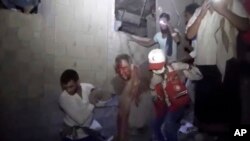 This photo provided by Ansar Allah Media Office, a man is rescued on Jan. 21, 2022, after Saudi-led airstrikes targeted a site in the contested city of Hodeida, Yemen.