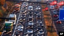 Cars and trucks queue on the highway A5 in Frankfurt, Germany, Nov. 6, 2017. Some in the EU propose cutting emissions of carbon dioxide from cars by 30 percent by 2030 but others say the plan is too ambitious to be economically sustainable.