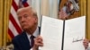 FILE - President Donald Trump holds up an executive order in Washington, Jan. 23, 2025. Since he took office, Trump signed several executive orders, including ones withdrawing the U.S. from the World Health Organization and the Paris Climate Agreement.