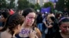 FILE - A woman writes the word "Free" on her friend at an event marking International Women's Day in Santiago, Chile.
