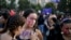 FILE - A woman writes the word "Free" on her friend at an event marking International Women's Day in Santiago, Chile.