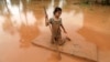A girl uses a mattress as a raft during the flood after the Xe Pian Xe Namnoy hydropower dam collapsed in Attapeu province, Laos July 26, 2018.