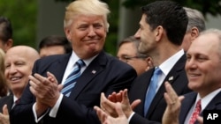 FILE - President Donald Trump acknowledges House Speaker Paul Ryan, in the Rose Garden of the White House in Washington, May 4, 2017, as House Republicans celebrate passage of health care bill to replace former president Barack Obama's signature plan. The Senate has yet to approve the replacement bill.