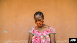 FILE - A woman checks her phone in Yaounde, Cameroon, April 23, 2020. 