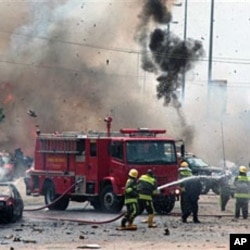 Smoke and debris fill the sky after a car bomb explodes alongside firemen responding to an initial car bomb that had exploded five minutes earlier in Abuja, Oct 1 2010
