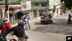 A police truck takes two detainees to the police station of Petion Ville in Port-au-Prince, Haiti, July 8, 2021. According to Police Chief Leon Charles, the two detained are suspects in the assassination of Haitian President Jovenel Moïse.