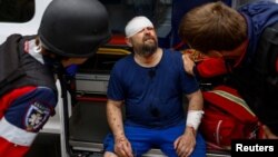 Nhân viên ứng cứu giúp đỡ một người dân địa phương bị thương trong cuộc không kích của Nga, ở Kharkiv, Ukraine, ngày 18 tháng 5 năm 2024.