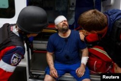 A wounded man gets medical care after a Russian air strike in Kharkiv, Ukraine.