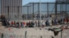 Migrantes formados después de ser detenidos por las autoridades migratorias de Estados Unidos en el muro fronterizo, el miércoles 27 de diciembre, captados desde Ciudad Juárez, México.
