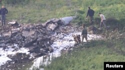 Pasukan keamanan Israelberjalan di dekat reruntuhan pesawat tempur F-16 dekat desa Harduf, Israel, 10 Februari 2018. 