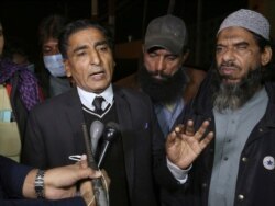 Lawyer Nadeem Ahmed Azar, L, and Sheikh Muhammad Aslam, brother of British-born Pakistani Ahmed Omar Saeed Sheikh, who is charged in the murder of American journalist Daniel Pearl, talks to media outside a prison in Karachi, Pakistan, Dec. 24, 2020.