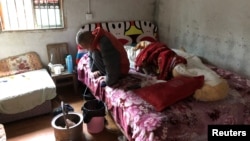 FILE - Wang Zhaohong, who suffers from silicosis, is seen on his bed in Sangzhi county, Hunan province, China, Nov. 27, 2018. 