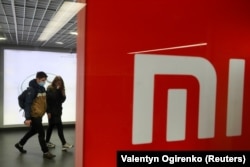 Orang-orang yang memakai masker pelindung wajah mengunjungi toko merek Xiaomi, di tengah wabah Covid-19 di Kyiv, Ukraina, 22 Oktober 2020. (Foto: REUTERS/Valentyn Ogirenko)