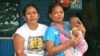 Santi with her four-month-old son and neighbor. The 26-year-old mother says she cannot afford birth registration for her children, Jakarta, Indonesia, March 2, 2013. (K. Lamb/VOA)
