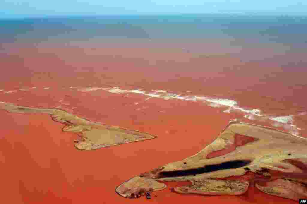 Handout picture released by the Espirito Santo State Press Office showing an aerial view of the Doce River--which was flooded with toxic lama after a dam owned by Brazilian Vale SA and Australian BHP Billiton Ltd burst early this month -- flowing into the Atlantic Ocean in Regencia, Espirito Santo State, Brazil, Nov. 24, 2015.