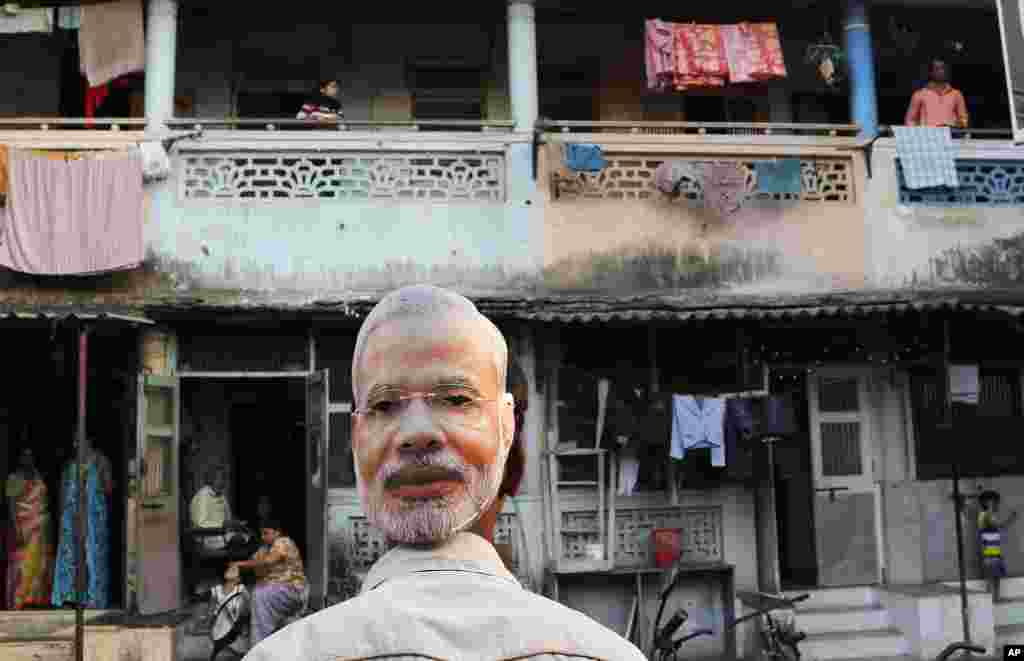 A supporter of India&#39;s main opposition Bharatiya Janata Party wears a mask depicting the face of Prime Minister candidate Narendra Modi, during an election rally in Mumbai, April 9, 2014.