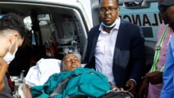Somalia's government spokesperson Mohamed Ibrahim Moalimuu, who was injured at the scene of an explosion, is assisted for medical evacuation to Turkey at the Aden Abdulle Osman International Airport in Mogadishu, Somalia, Jan. 17, 2022.