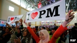 Malaysian Izzati Zaidi (R), 24, and her friends show placards in support of Malaysia's Prime Minister Najib Razak during the launch of the "Voices of My Generation" youth programme in Kuala Lumpur, April 12, 2013.