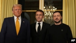 French President Emmanuel Macron, center, poses with President-elect Donald Trump, left, and Ukraine's President Volodymyr Zelenskyy at the Elysee Palace, Dec. 7, 2024 in Paris. 