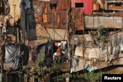 A man brushes his teeth outside a shanty in Dharavi, one of Asia's largest slums, in Mumbai, India, Dec. 27, 2016.