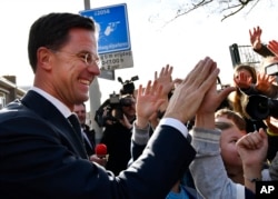 Dutch Prime Minister Mark Rutte gives high fives to children after casting his vote in the Dutch general election in The Hague, Netherlands, March 15, 2017.