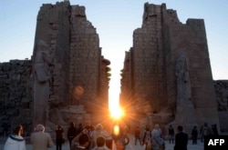 The sun rises behind the Temple of Karnak during the alignment of the winter solstice sunrise to the temple in the southern Egyptian city of Luxor on December 22, 2015.