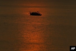 FILE - Cambodian fishermen catch fish in the middle of Mekong river, near Phnom Penh, Cambodia, March 7, 2018.