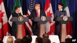 FILE - Mexico's President Enrique Pena Nieto, left, shakes hands with President Donald Trump as Canada's Prime Minister Justin Trudeau looks on as they prepare to sign a new United States-Mexico-Canada Agreement.