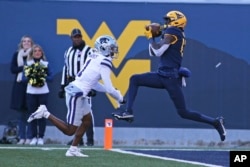 FILE - West Virginia wide receiver Sam James catches a touchdown pass while defended by Kansas State safety Josh Hayes during the first half of an NCAA college football game in Morgantown, W.Va., Saturday, Nov. 19, 2022. (AP Photo/Kathleen Batten)