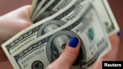 A woman counts U.S. money in Buenos Aires, Argentina, Aug. 28, 2018. 