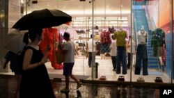 FILE - Chinese customers stroll past a clothing shop at Taikoo Li Sanlitun in Beijing, July, 30, 2024. Chinese economic policymakers are expected to on Oct. 8. to flesh out policies to boost growth.