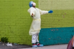A medic of the Elmhurst Hospital Center medical team reacts after stepping outside of the emergency room on April 4, 2020, in the Queens borough of New York.